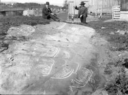 To menn fotografert ved helleristninger på Bergheim i Gjerpe