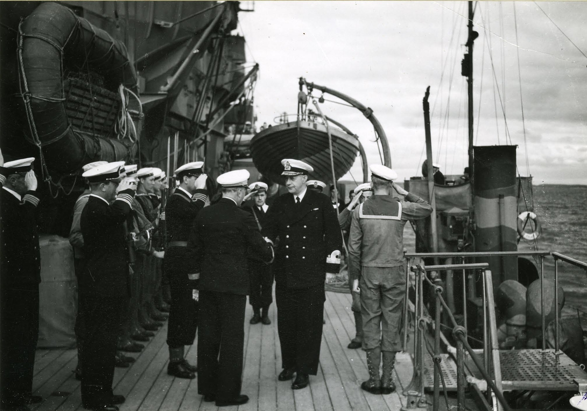 K.amiral C.F. Tamm (Chef för marinen) på inspektion på psk Sverige i samband med kungaskjutningen 1944.
Med ryggen hitåt: Kont.amiral Yngve Ekstrand, chef för Kustflottan.
