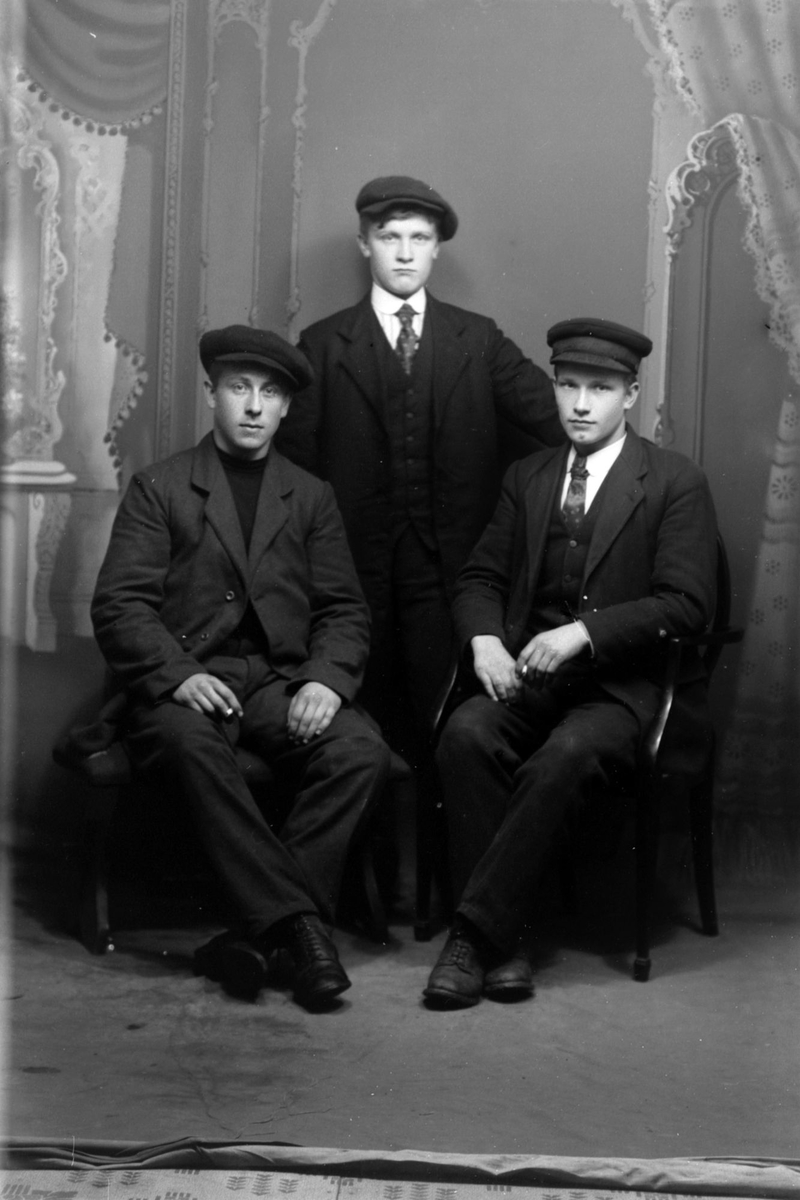 Studioportrett av tre unge menn.