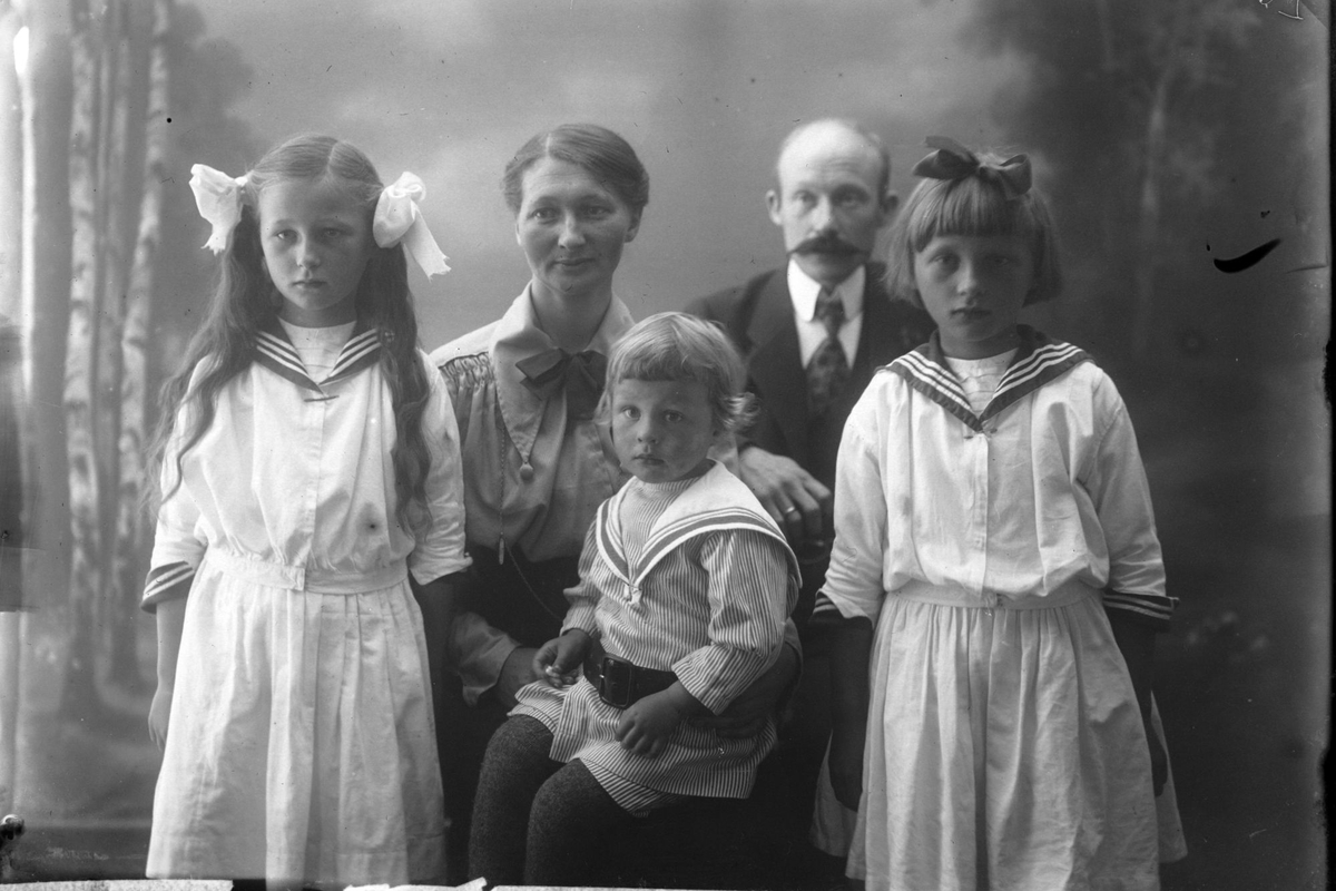 Studioportrett av en mann og kvinne med tre barn kledd i matrosdress.