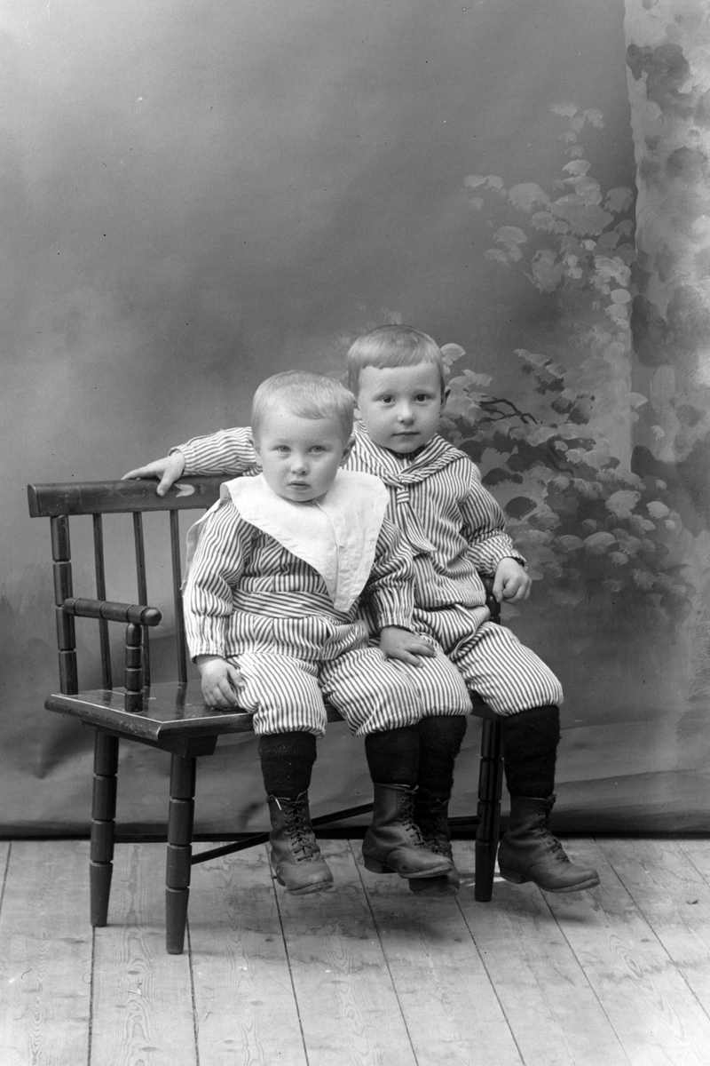 Studioportrett av to barn i helfigur, trolig brødrene Olsen.