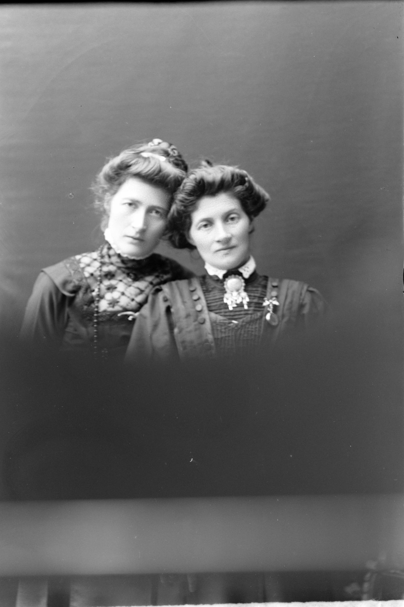 Studioportrett av to kvinner i halvfigur.