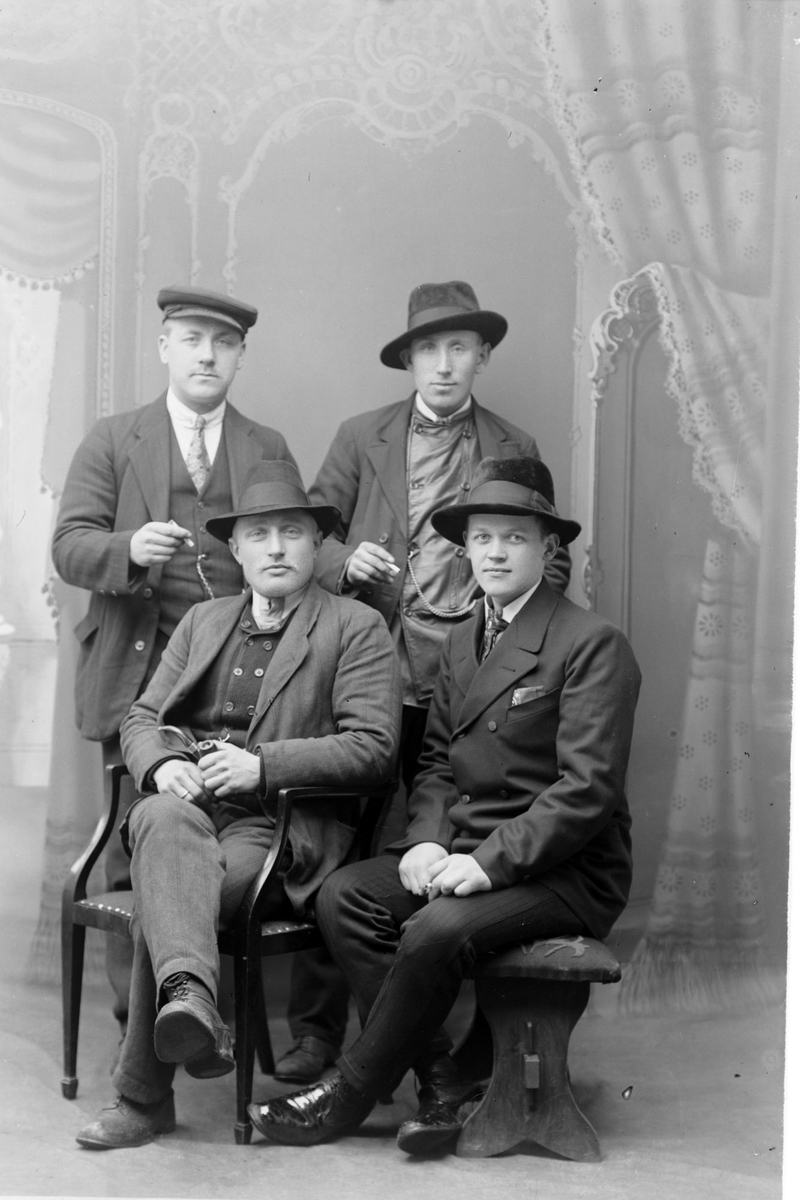 Studioportrett av fire menn.