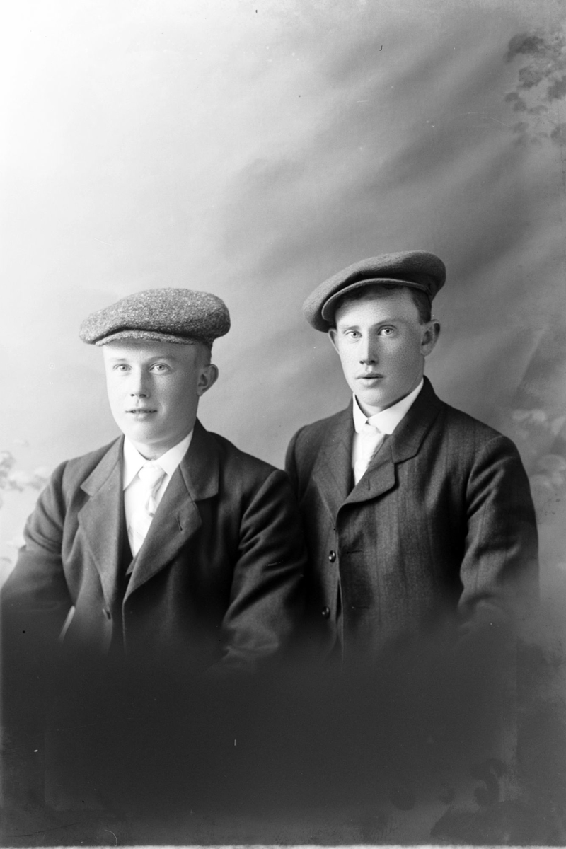 Studioportrett av to menn med sixpence på hodet.