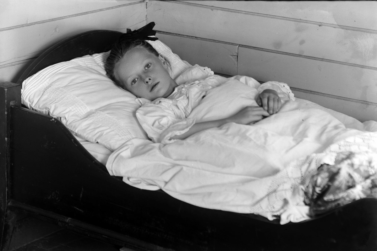 Portrett av en ung pike i seng.