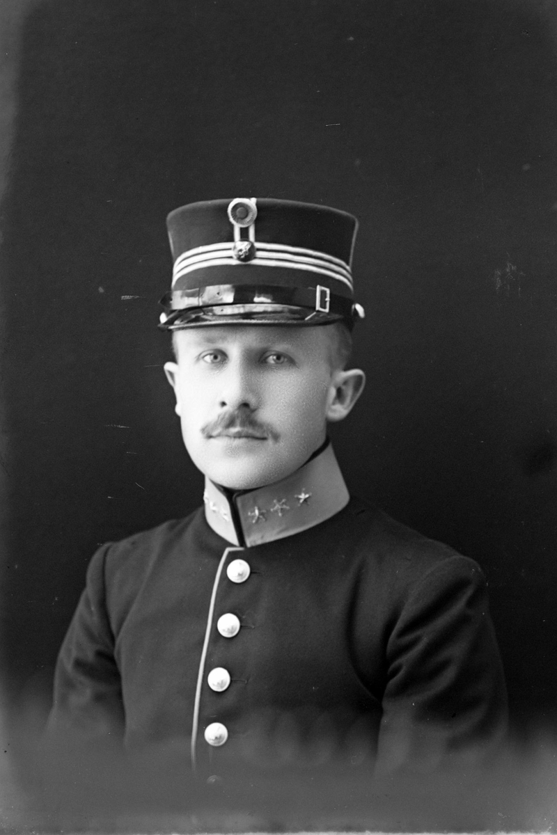Studioportrett i halvfigur av en mann i uniform.
