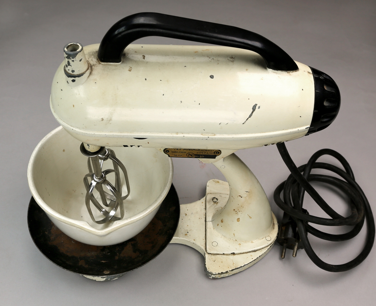 Kjøkkenmaskin ("mix master") bestående av stativ som holder to visper, og platting for plassering av bolle under. Oppå er det et håndtak. Den drives på strøm og har en ledning bakpå