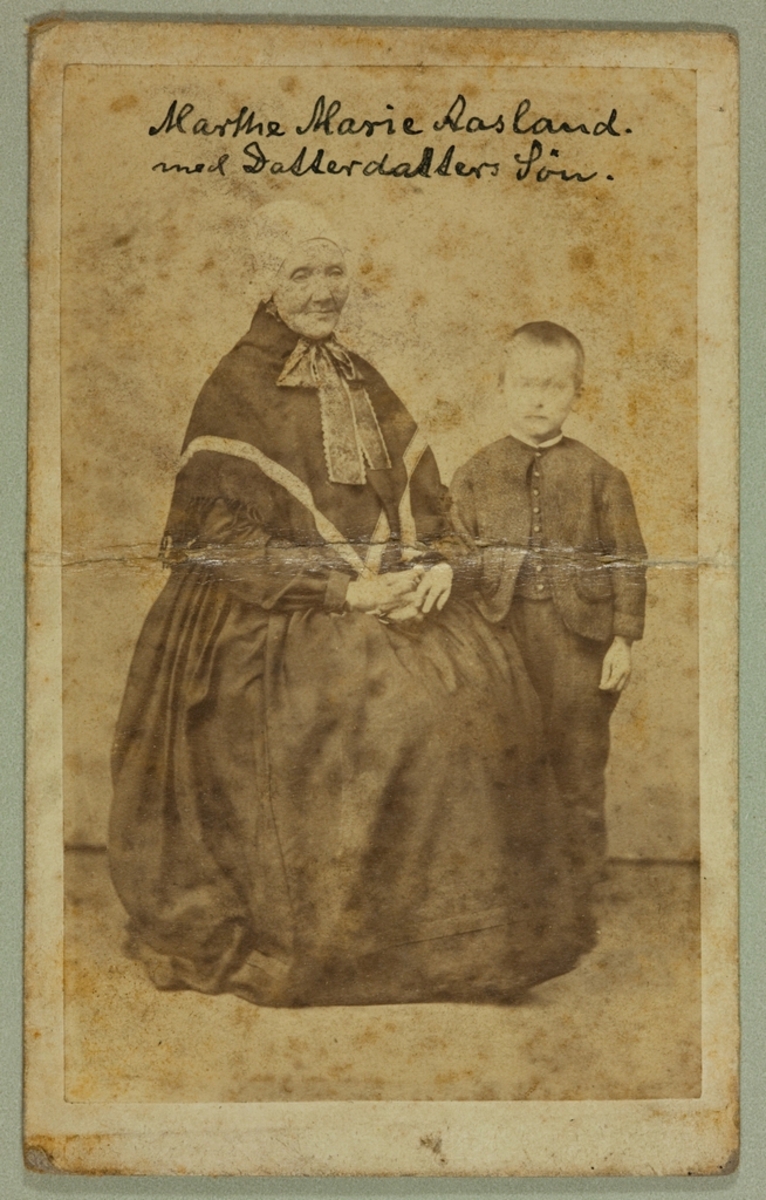 Portrett av ei eldre kvinne med eit barnebarn.