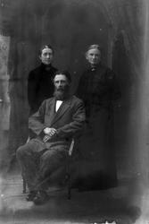 Studioportrett i helfigur av en mann og to kvinner.