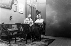 To kvinner fotografert i Magdalene Normans studio. Bakteppe 