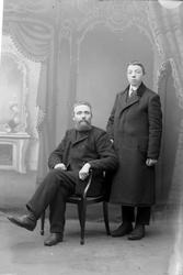 Studioportrett av to personer i helfigur.