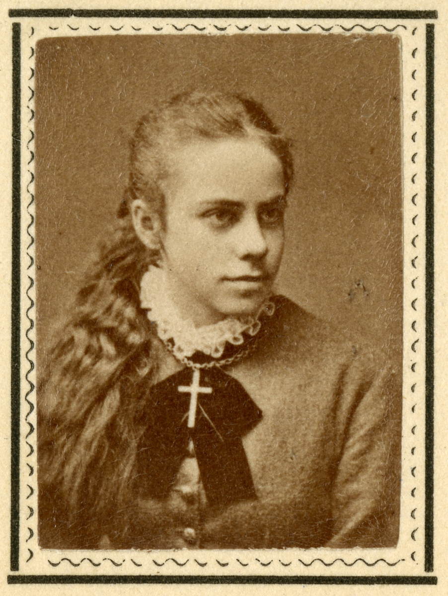 Visittkort med portrett av Hilma Bing. På baksiden står det skrevet "Tusind Tak! Hilsen fra".  Kortet ligger i en konvolutt med påskriften "Hr Albert Larsen i Christiania" og "Mai 1880" på forsiden. Vedlagt ligger også et bilde av en bygning fra Wien. På baksiden står det skrevet "Mottaget i  München 10/2 88". Fra gjørtlerfirmaet C. P. Larsens arkiv.