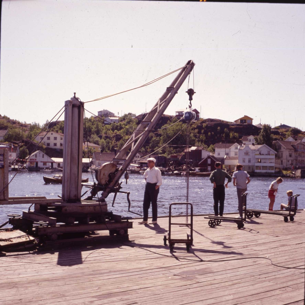 Kran og folk på Fiskebrygga, ca. 1960. Øya i bakgrunn.