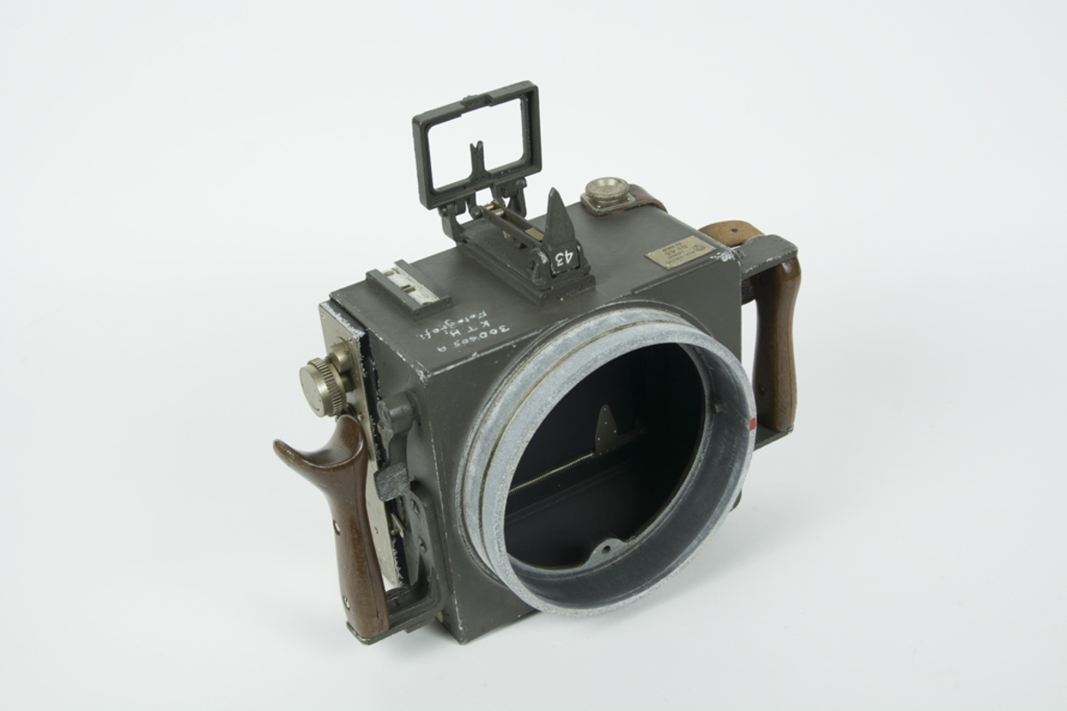 Handkamera Hk 6. Nr 43 i transportlåda med diverse tillbehör. Till kameran ingår en löstagbar objektivtub med skyddslock. På kamerans ovansida finns en inristad text: 300405 A, K.T.H., Fotografi. Har tidigare använts på F3 Malmslätt.