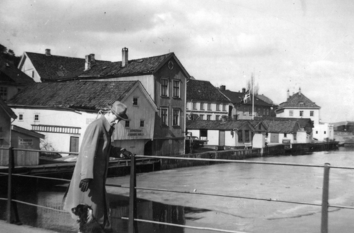 Torbjørn Myhren, dommerfullmektig i Kragerø 1953 -1955, står på bybrua. bebyggelsen ved Blindtarmen bak han.