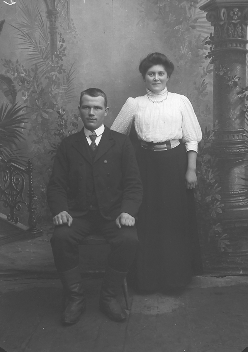 Portrett. Par i 20-åra. Mannen sitter.Bildet er tatt på Reine i Lofoten.