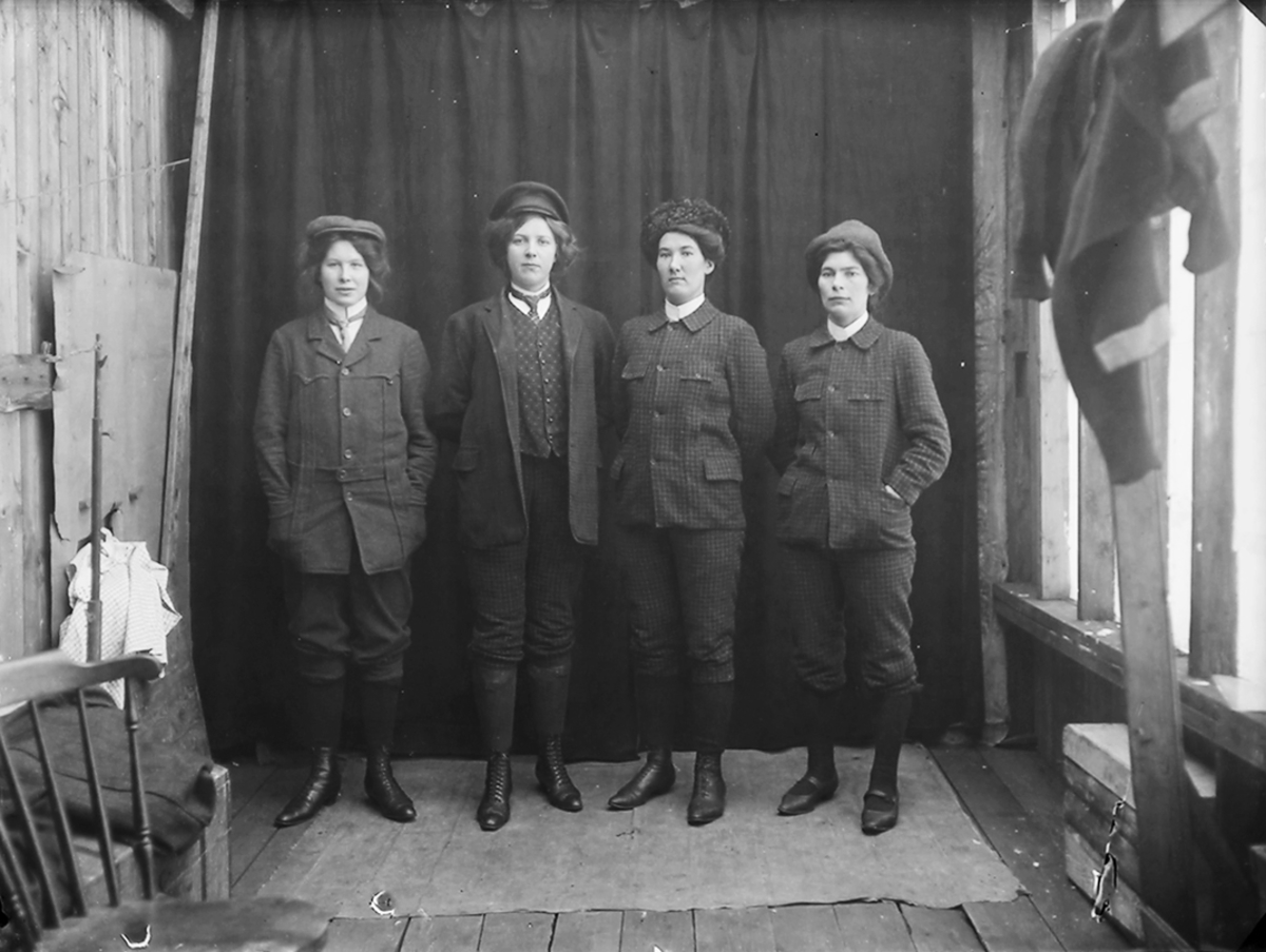 Gruppebilde. 4 jenter har kledt seg ut som menn. Nr. 3 fra venstre er Paula Josefine Pettersen, f. 1887. Nr 4 fra venstre er Magda Johansen, f. 1891.