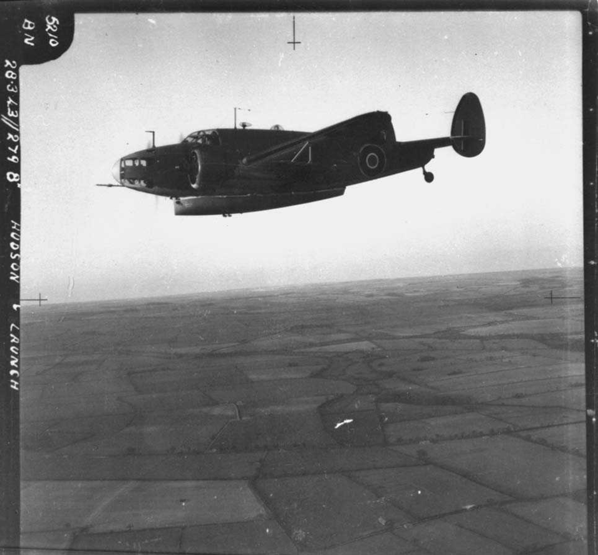 Luftfoto. Ett fly i lufta, Lockheed Hudson fra RAF. En liten båt festet under flyet.