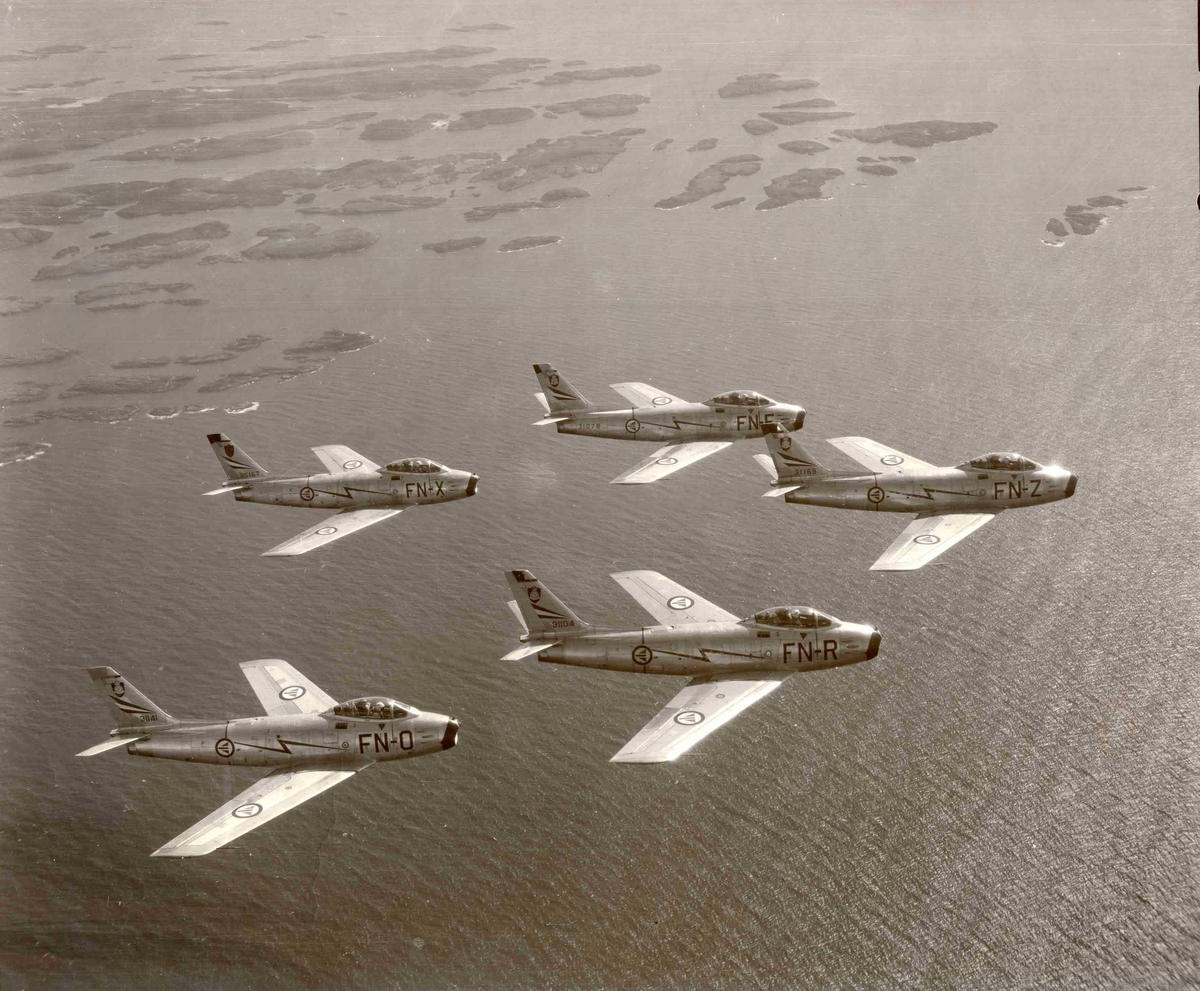 Luftfoto av fem F-86F Sabre tilhørende 331 skv  i formasjon. 
FN-O ser 53-1141
FN-R ser 53-1104
FN-F ser 53-1078
FN-X ser 52-5167
FN-Z ser 53-1169
Se også NL.03010013-14-15
                NL.04160039-40
                NL.99330066-67