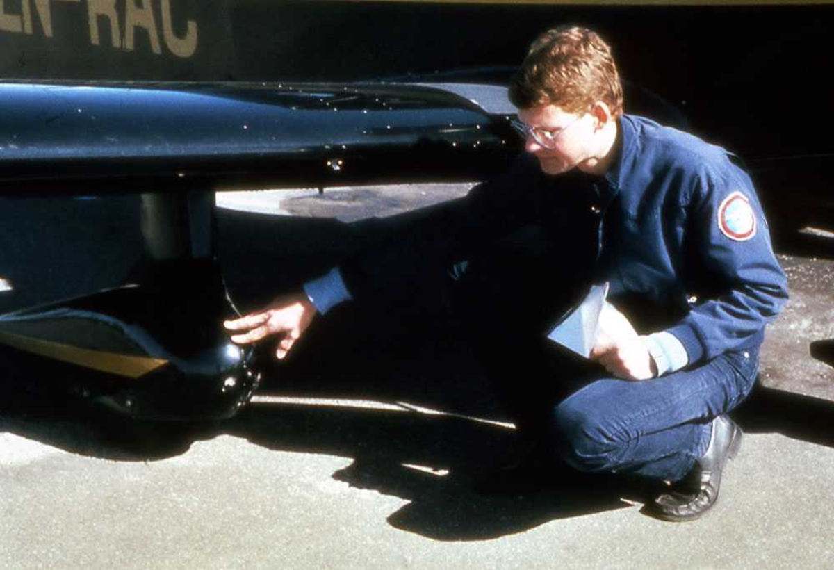 Ett fly på bakken. LN-RAC, Robin R.2160. En person på kne ved flyet. Inspeksjon. 