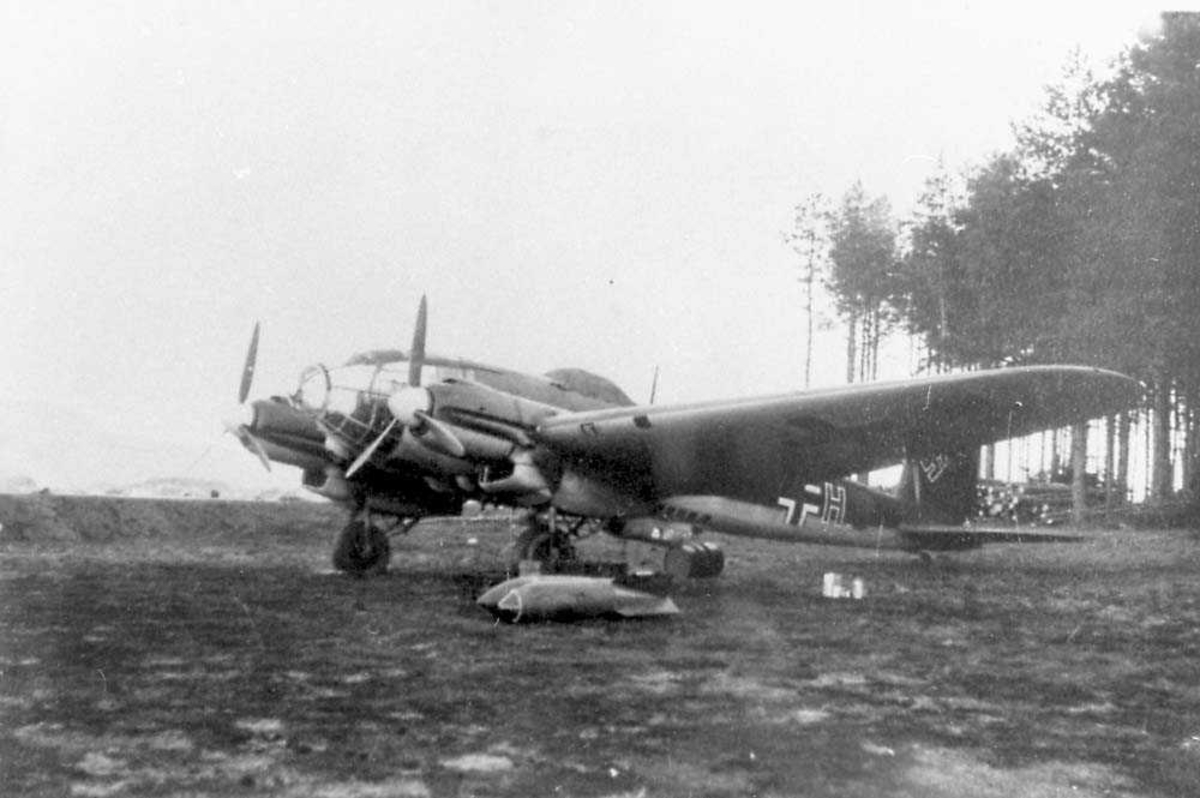 Ett fly på bakken. Heinkel He 111. Noen bomber ligger under flyet.