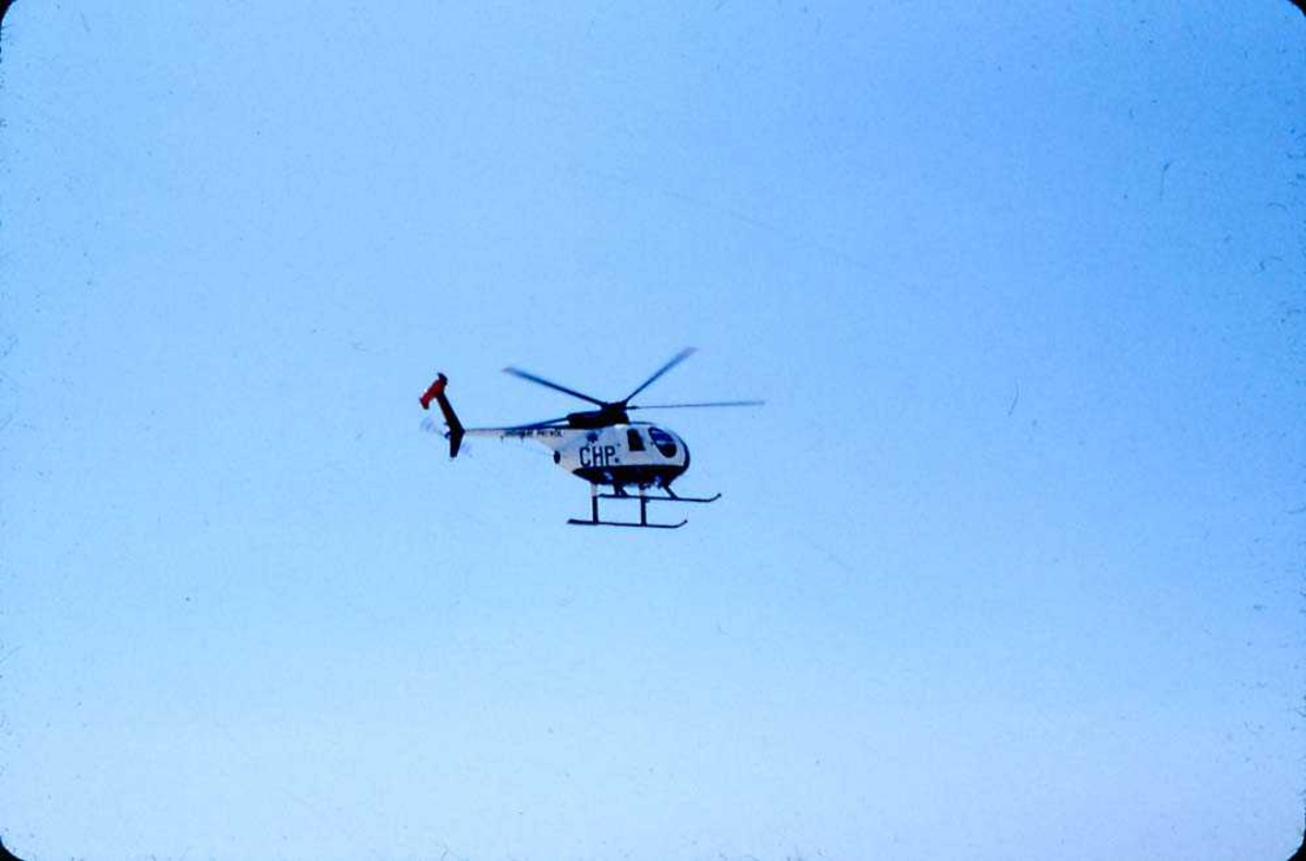 Luftfoto fra flystevne. Ett helikopter i luften, Hughes 500.