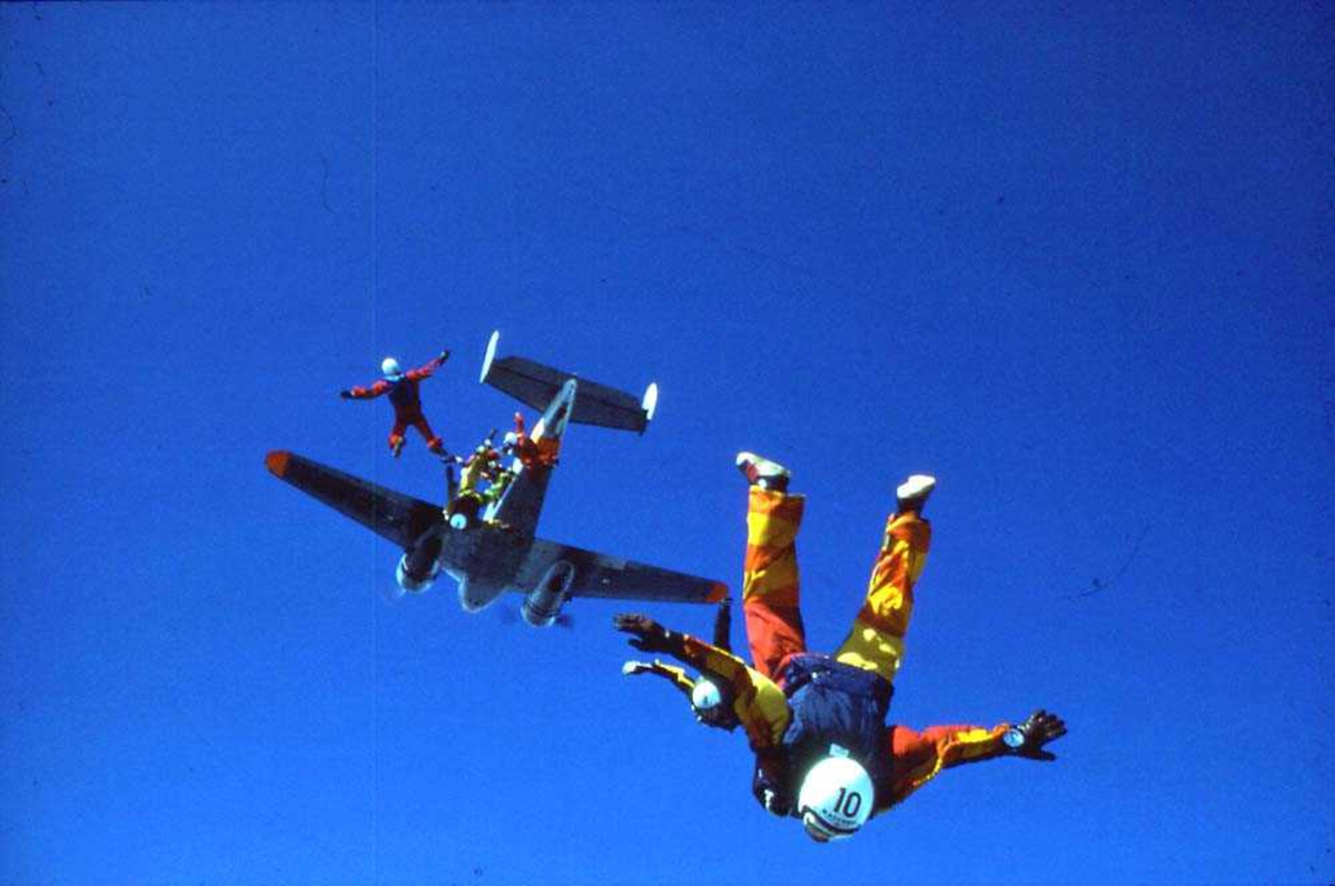 Luftfoto. Flere fallskjermhoppere som hopper ut av et fly.