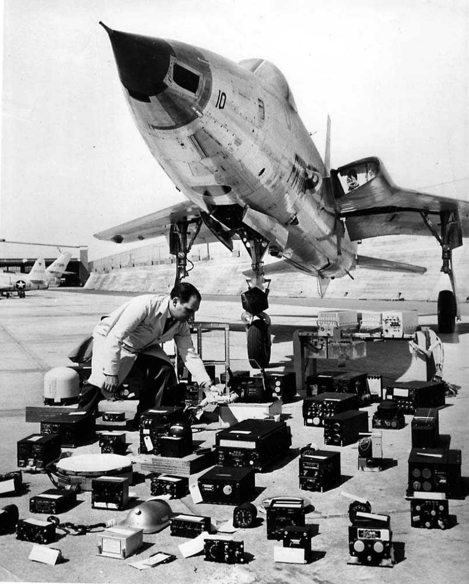 Ett fly på bakken med flere elektroniske instrumenter liggende foran flyet. Republic F-105D Thunderchief. En person ved instrumentene.