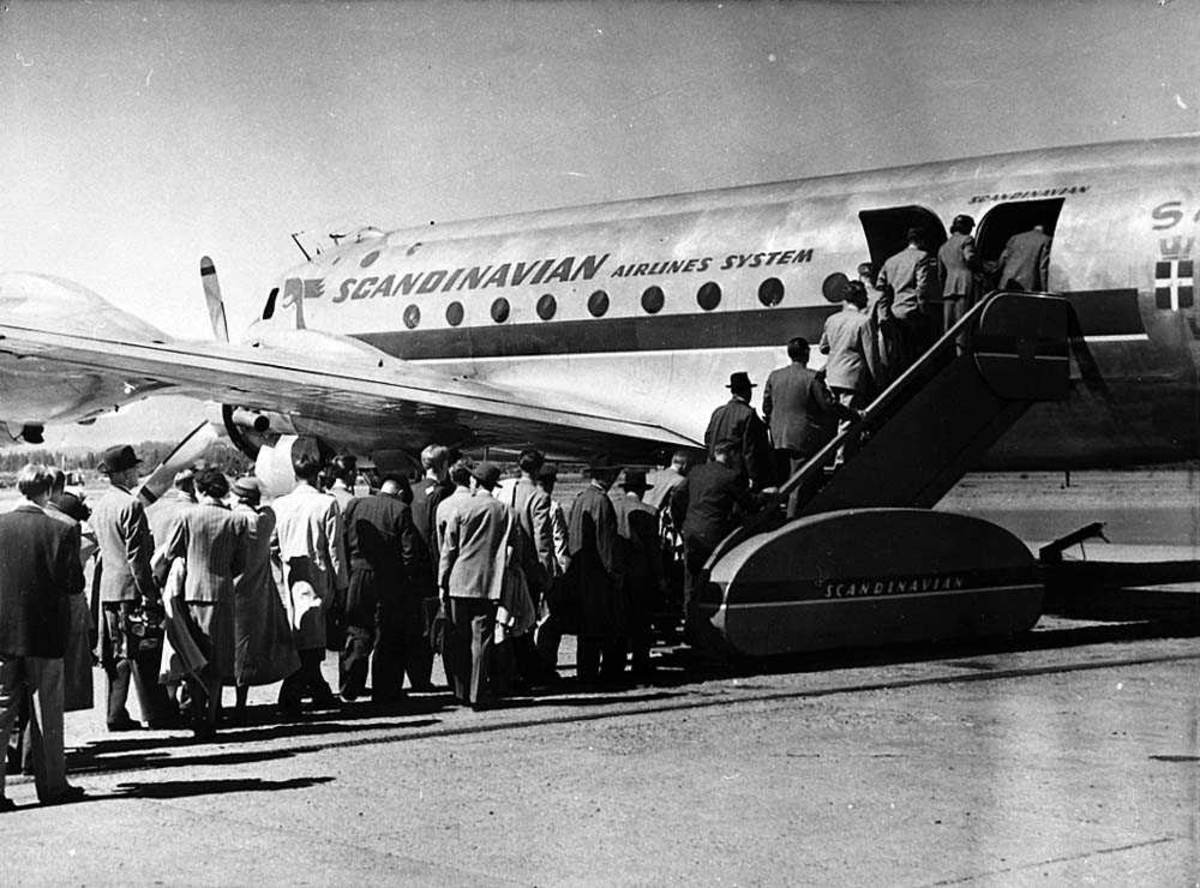 Lufthavn. Flere passasjer på vei ombord i et fly, Douglas DC-4/C-54 fra SAS.