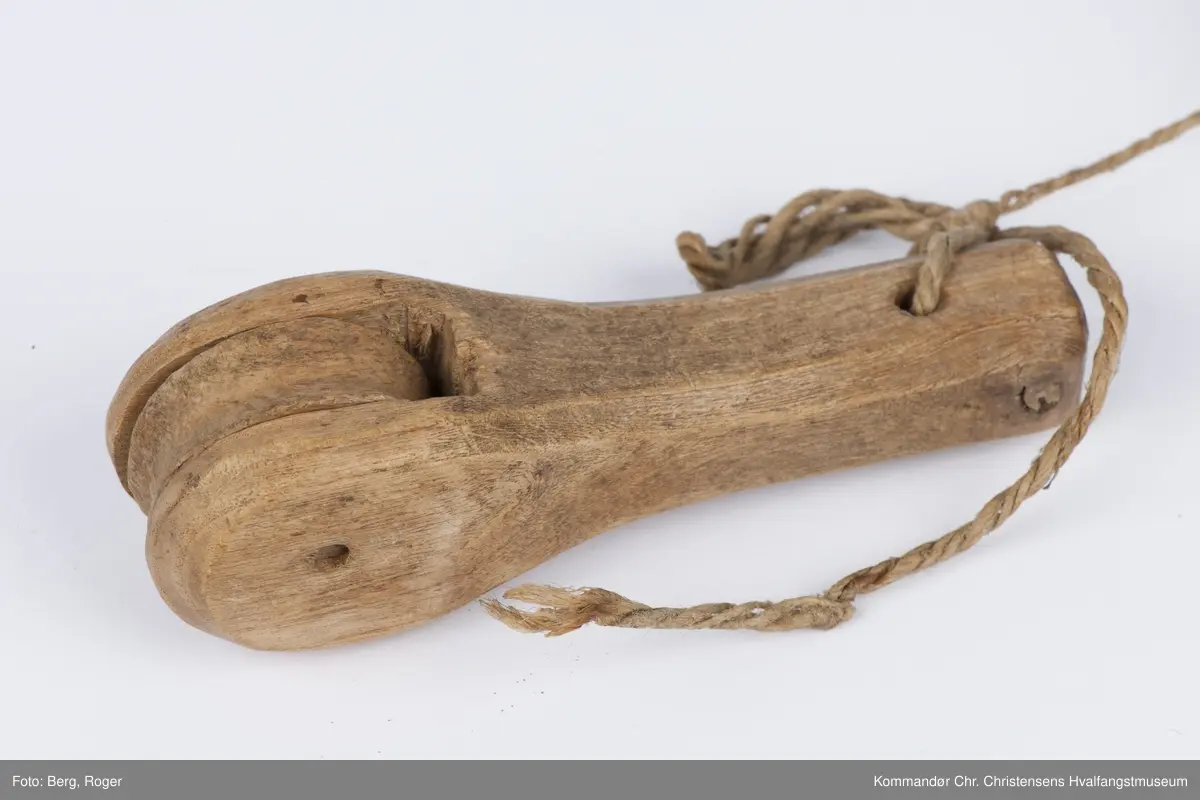 Teknikk: Håndarbeid. Utskåret i pæreform. Hakk inn til trinsehjulene som ble festet v.h.a tre- nagler. Lintråd forbinder de ulike delene
