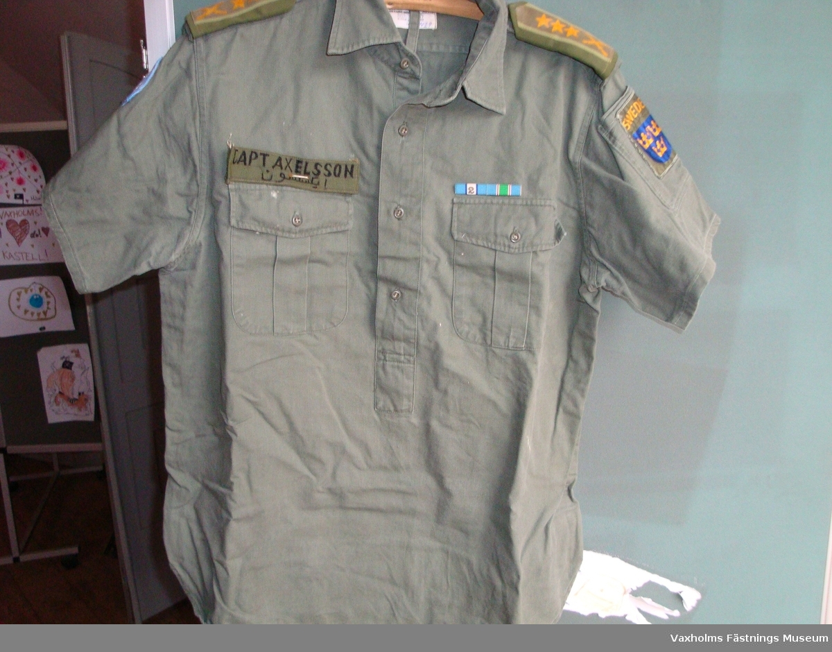 Uniform FN grön indisk modell,  skjorta med kort ärm och byxor. Blå fältmössa och blå halsduk.