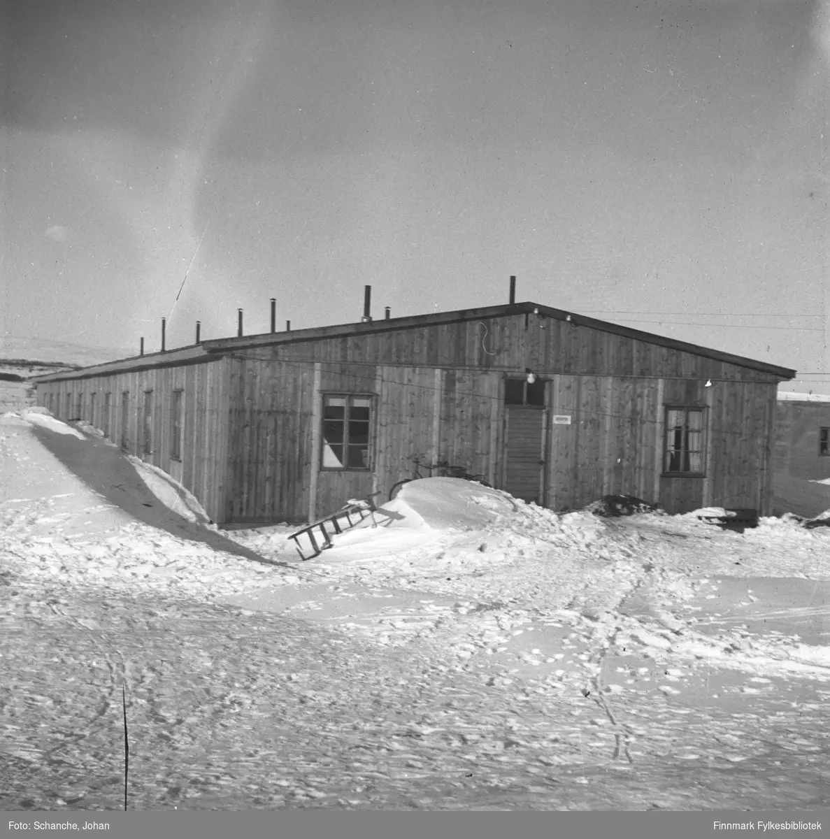 Den gamle politibrakken / sørenskriverkontor (-46-48) i Vadsø fotografert på vinter -46. Skilt på veggen med tekst:'sorenskriveren'.