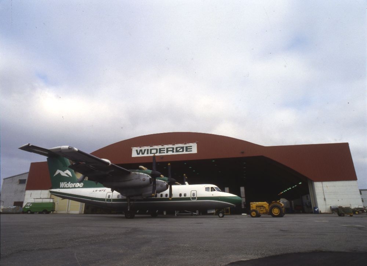 Ett fly foran bygning: LN-WFE, De Havilland DHC-7 (Dash7) fra Widerøe.