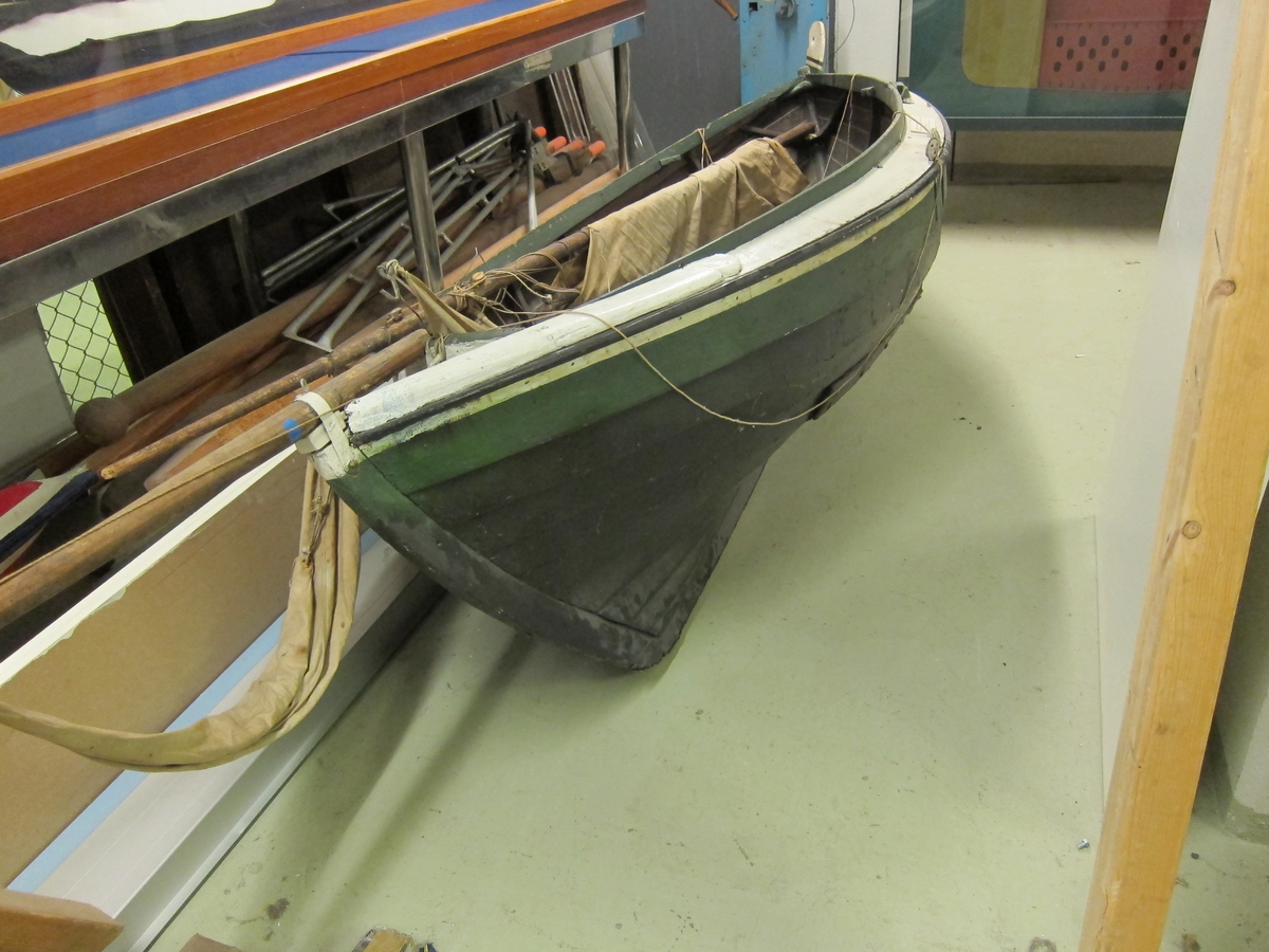 Trebåt med seilduk og to årer, mast med gaffelrigg, bomullsseil.