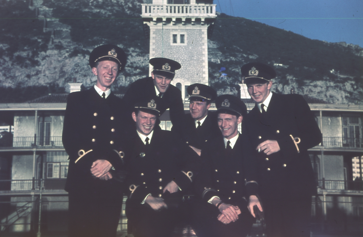 Sex Glada militärer framför ett hus.