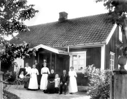 Familien til Anne Marie og Ludvig Finnestad foran våningshus