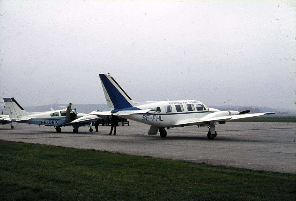Lufthavn. Ett fly på bakken, Piper PA-31-300 Navajo SE-FHL fra Business Air Service. Andre fly i bakgrunnen.