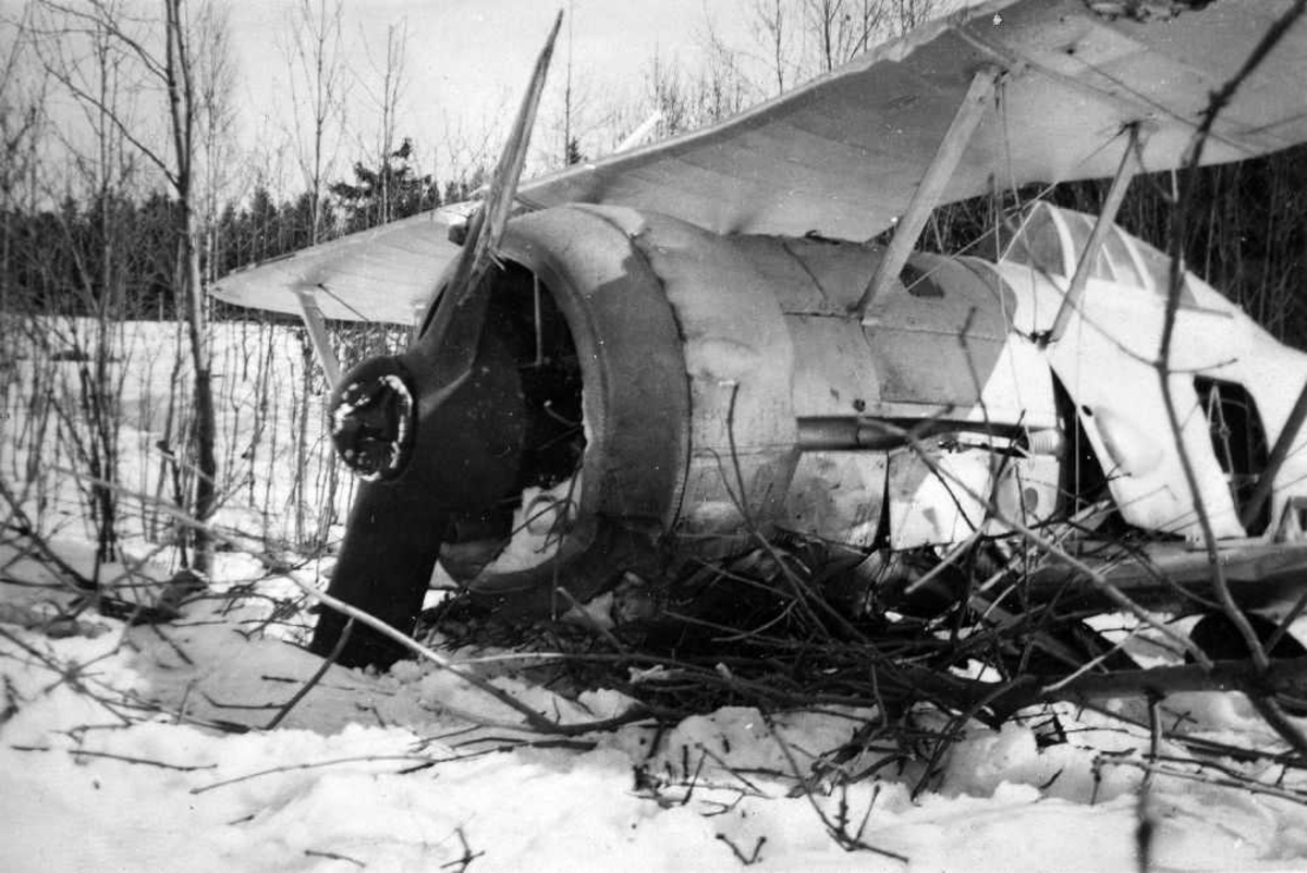 Landskap. Et fly, Gloster Gladiator, har styrtet på en snøkledd slette med kjerr. Flyet har fått betydelige skader.