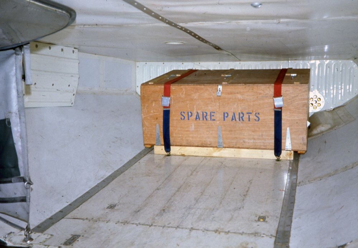 Lufthavn/Flyplass. I lasterommet til et fly fra Braathens SAFE, står en kasse inneholdende "spare parts" (reservedeler).
