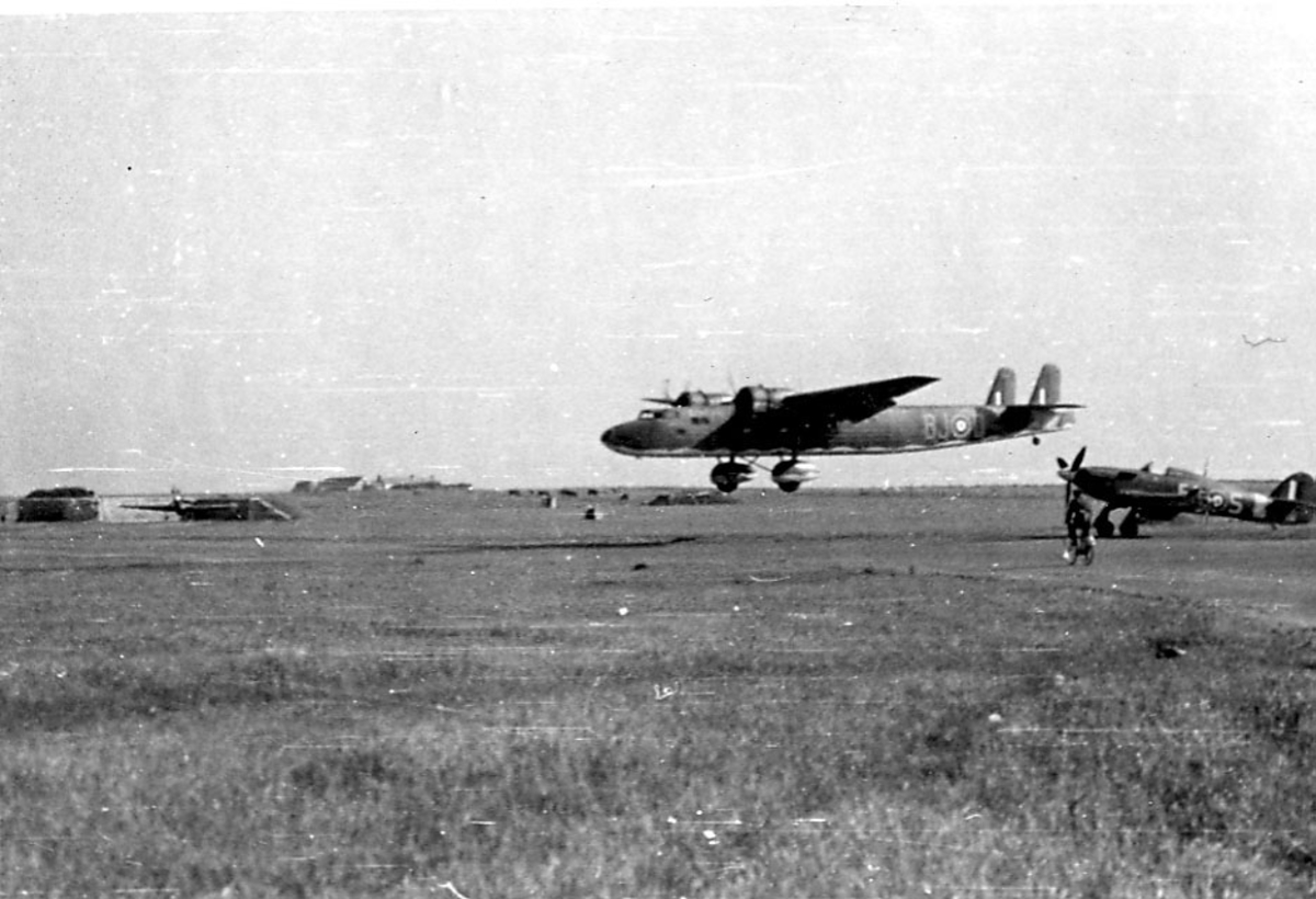 Åpen plass, ant lufthavn. to fly på bakken. Et større fly like over bakken. Person på sykkel t.h.
Fly på bakken Hawker Hurricane. Fly i luften Handley Page HP54 Harrow