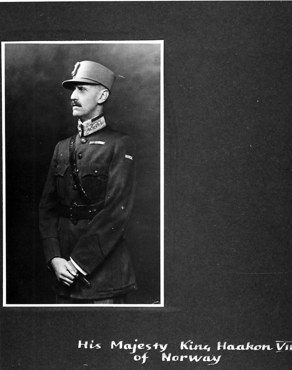 Portrett av Kong Haakon VII, i militæruniform. Håndskrevet tekst under bildet.