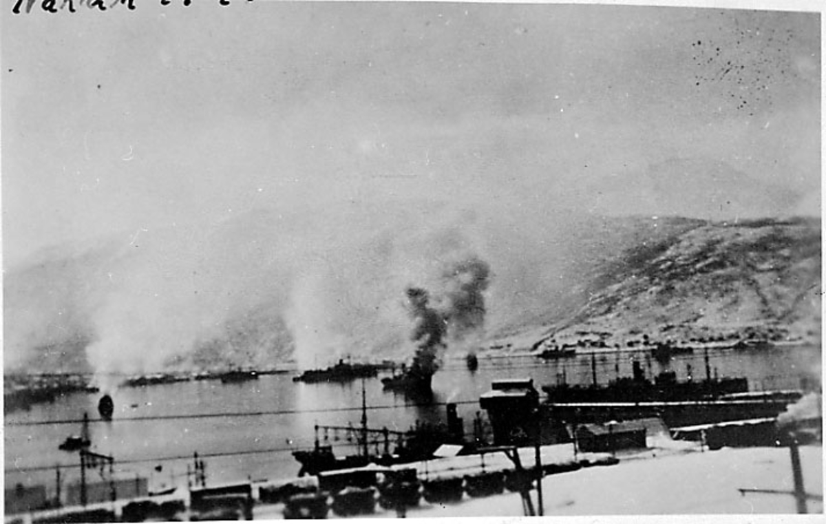 Krigsødeleggelser - bombing av Narvik under 2. vedenskrig. Havna med flere fartøyer i brann.