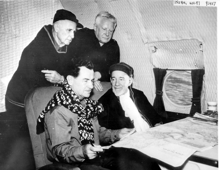 Portrett, 4 personer inne i et fly. Studerer et kart e.l. Flyet er ant. i lufta.
