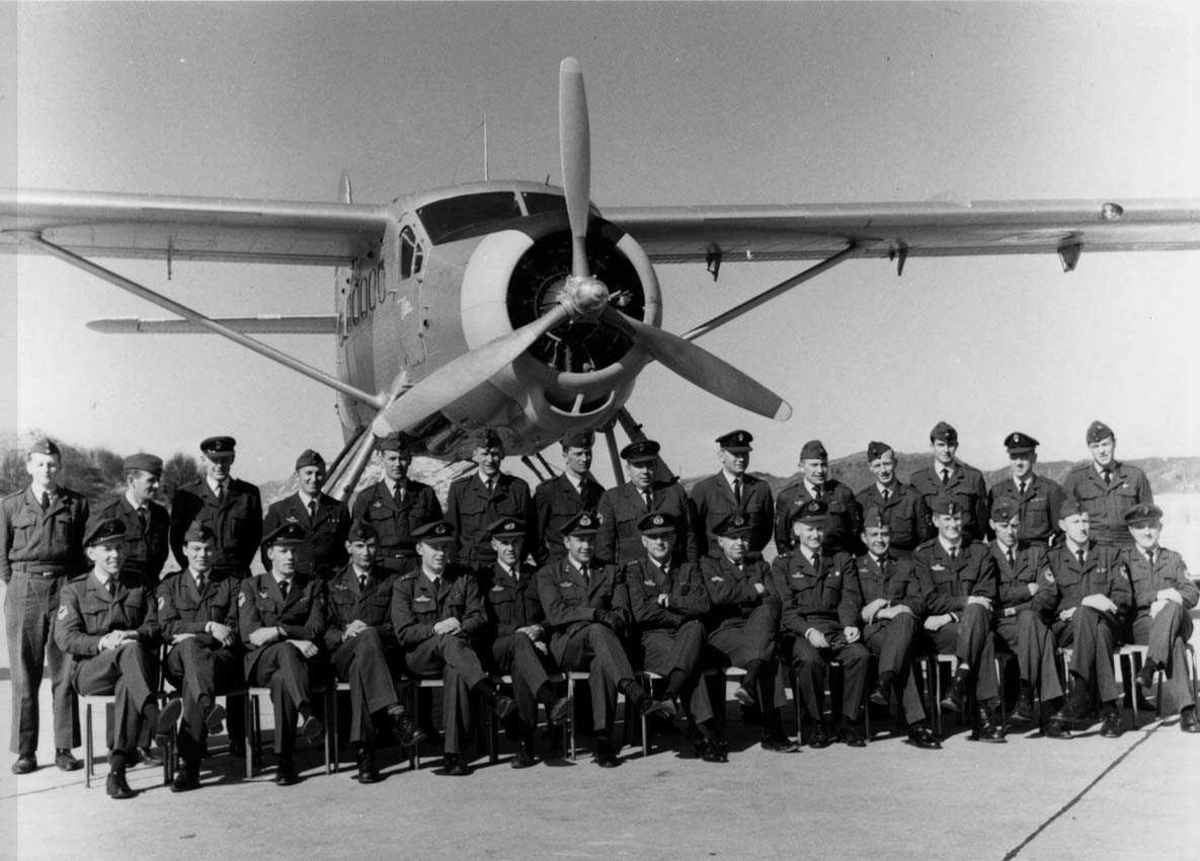 Militært personell. Gruppefoto. Mange personer, menn, oppstilt foran et fly, DHC-3 Otter. Fra 719 skvadronen