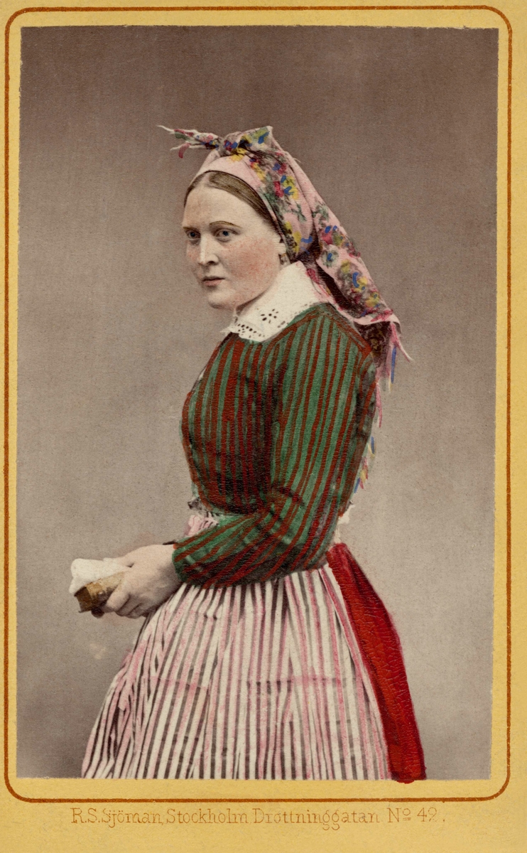 En kvinna klädd i vardagsdräkt, s.k halvdräkt från Vingåker i Södermanland.