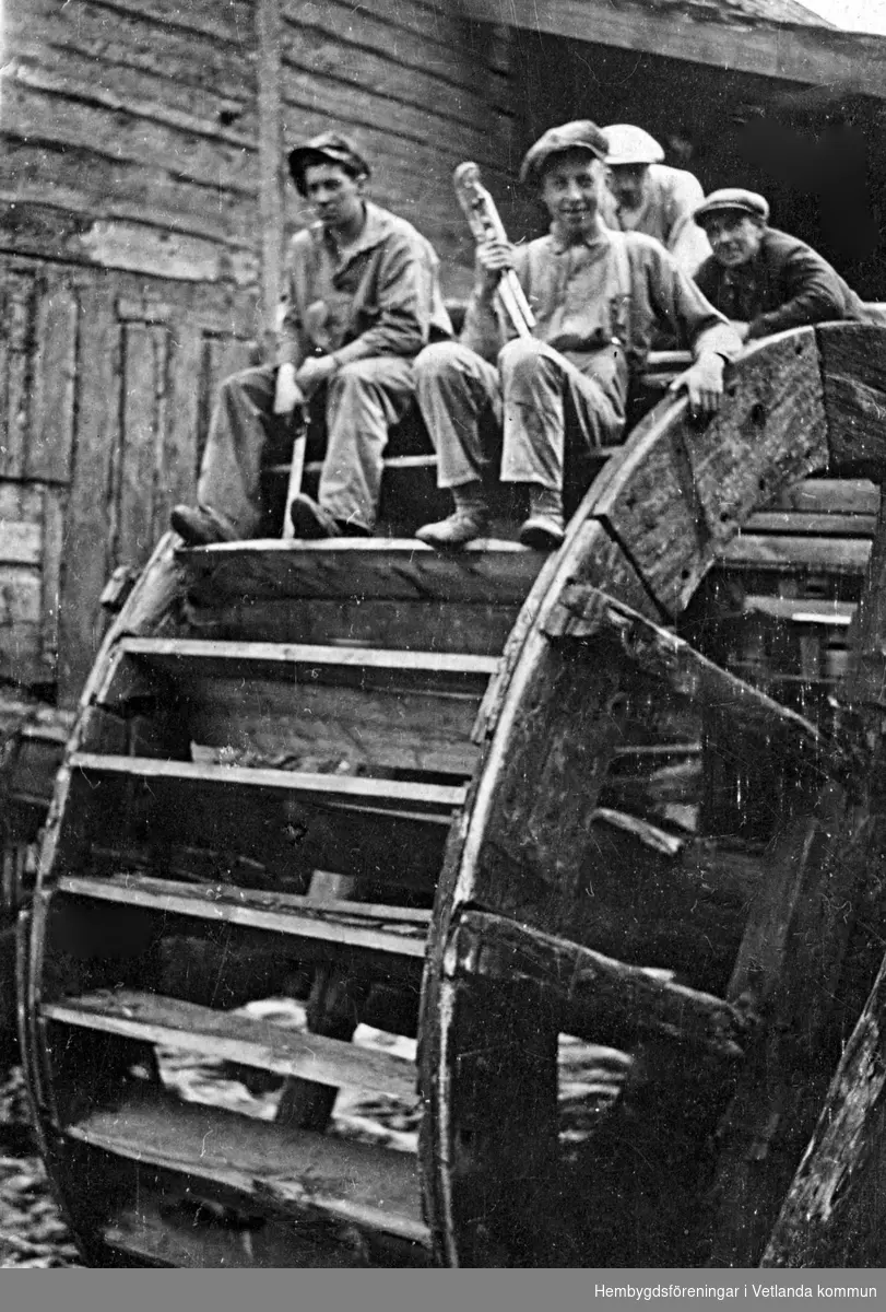 Några ur arbetsstyrkan vid Bäckseda Möbelverkstad och Nordiska Maskinfabriken sittande på vattenhjulet vid Mela kvarn. Bilden är tagen 1932. Från vänster: Elof Lundin, Olof Svensson, Oscar Svensson och Karl Nilsson.
