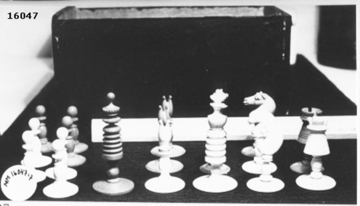 Utskuren schackpjäs, vit bonde, som står på cirkelrund fot.