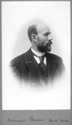 Portrett av ukjent mann. Han er kledt i mørk jakke, vest og 