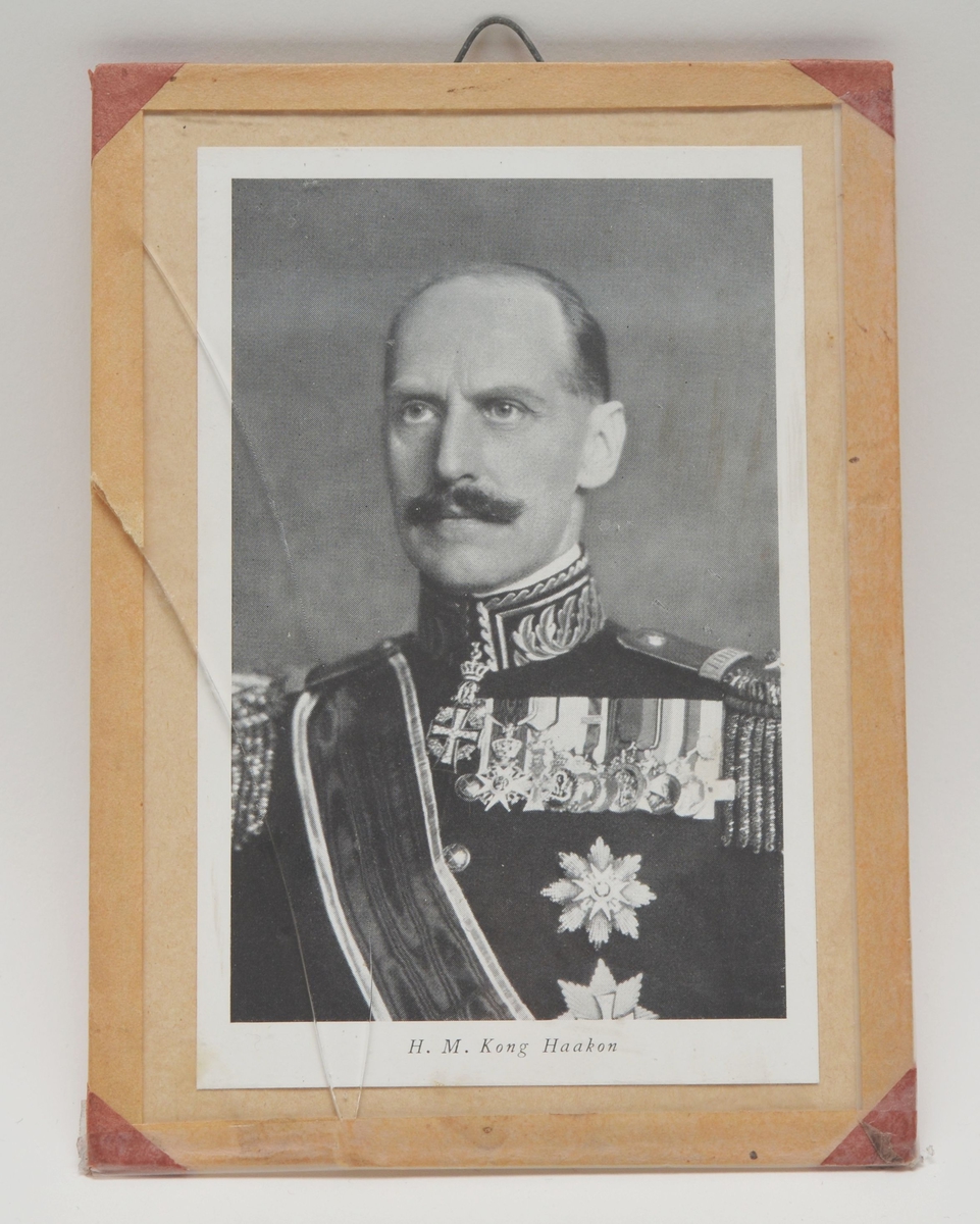 Motivet viser et (masseprodusert) portrett av kong Haakon 7.  i uniform. Trykket i sort/hvitt.