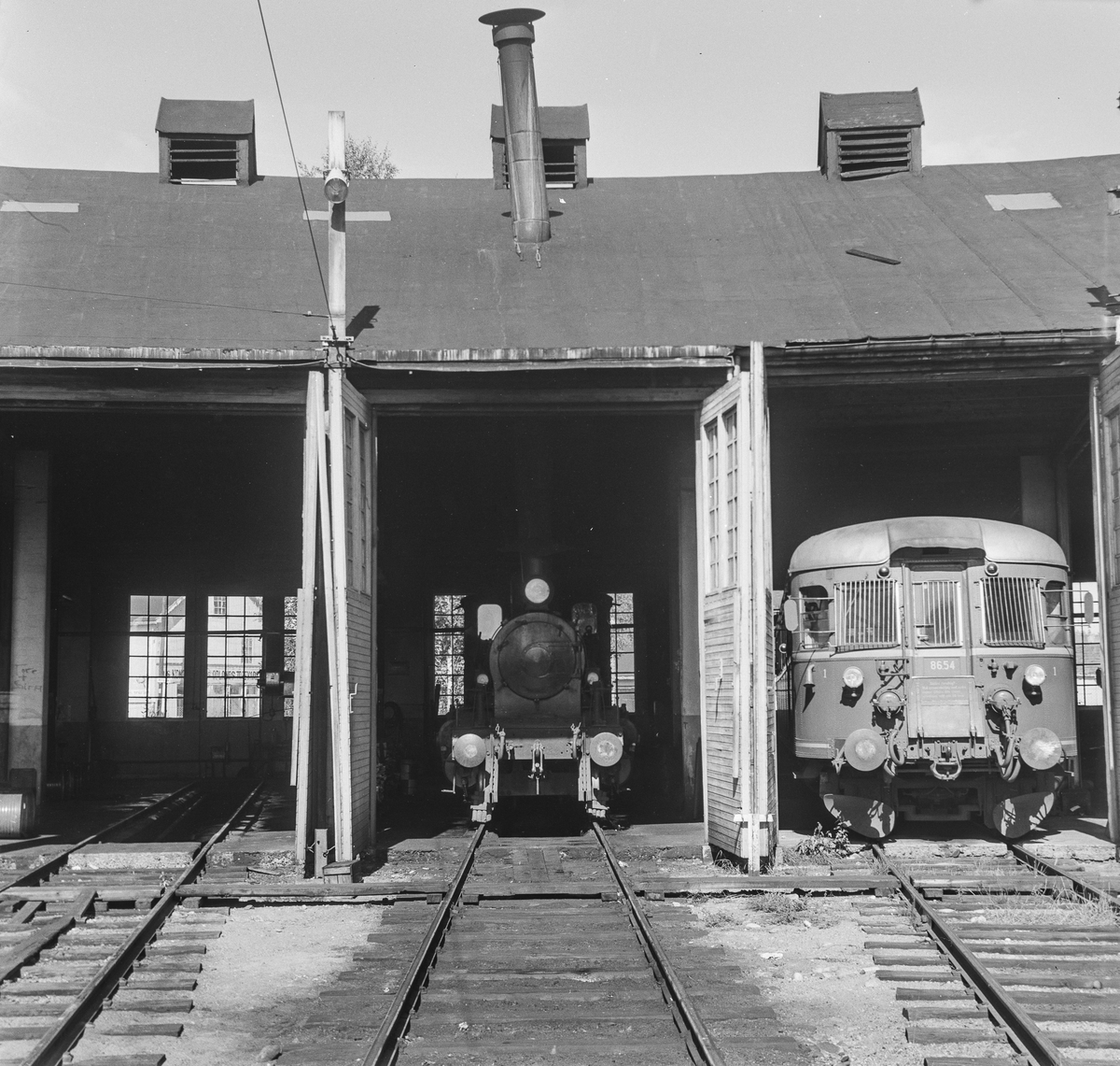 Lokomotivstallen på Kongsberg. I midten damplok type 21 nr. 225 eller 375, til høyre dieselmotorvogn type 86.